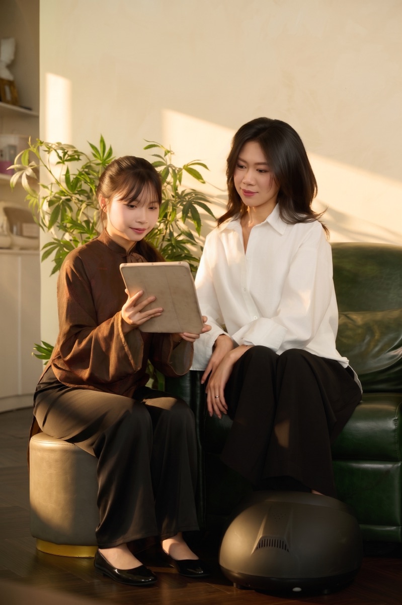 Nhân sự Gạo Nâu cầm tablet tư vấn cho khách tại lounge cơ sở Lê Văn Sỹ
